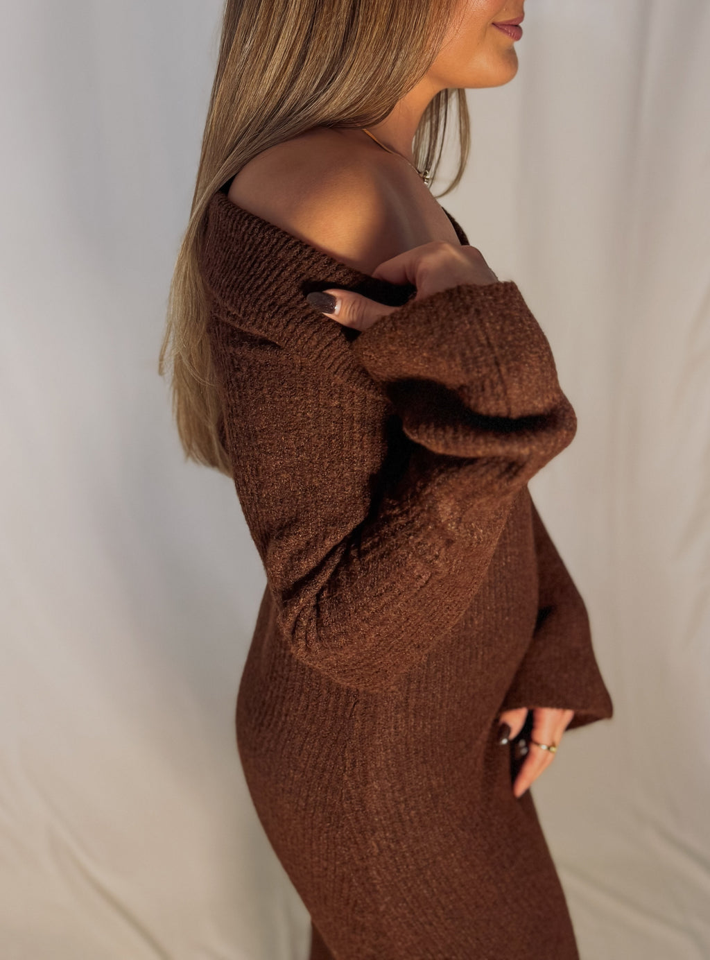 Brown knitted dress worn by a person on a plain background