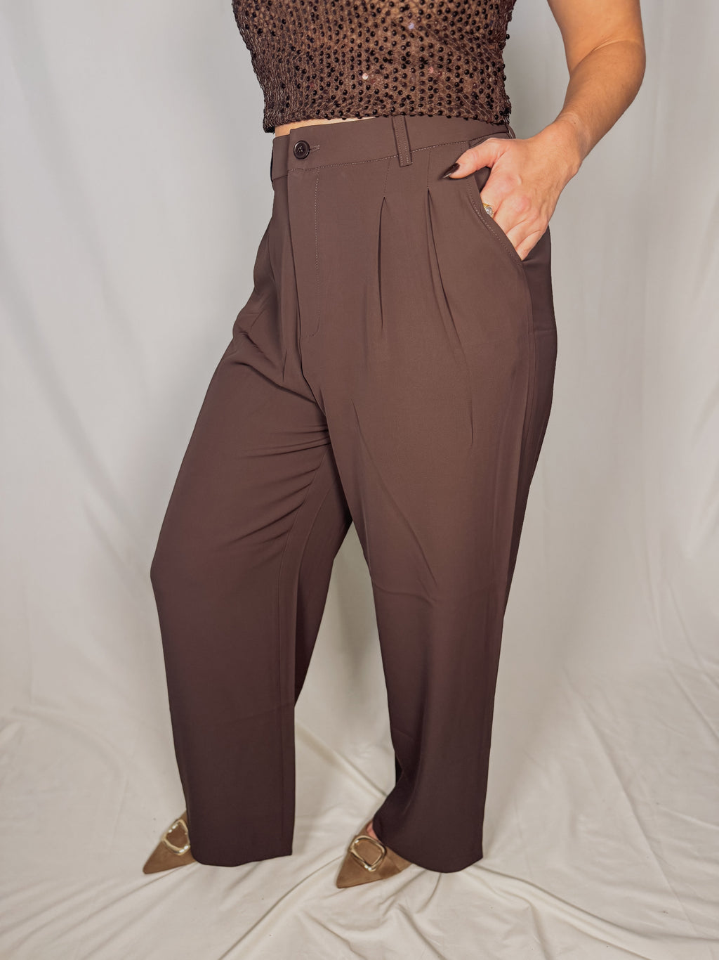Brown pants worn by a person on a plain background