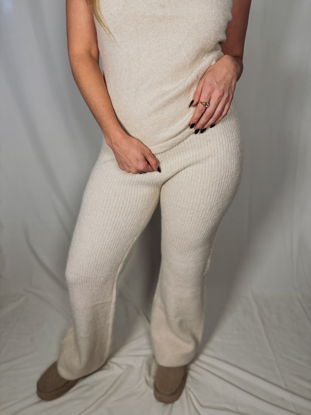 Person wearing a beige knit outfit against a plain background