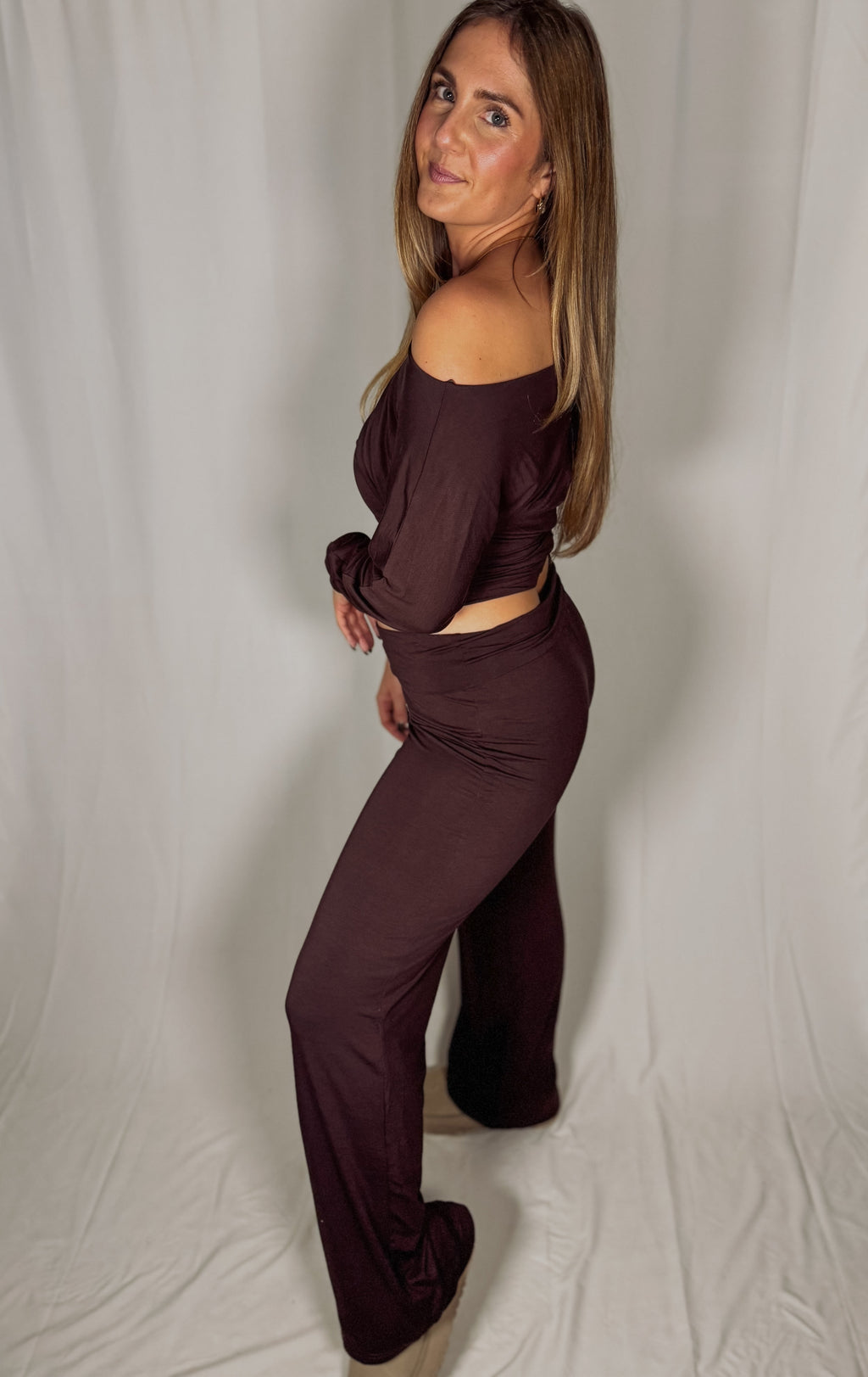 Woman wearing a brown outfit against a plain background