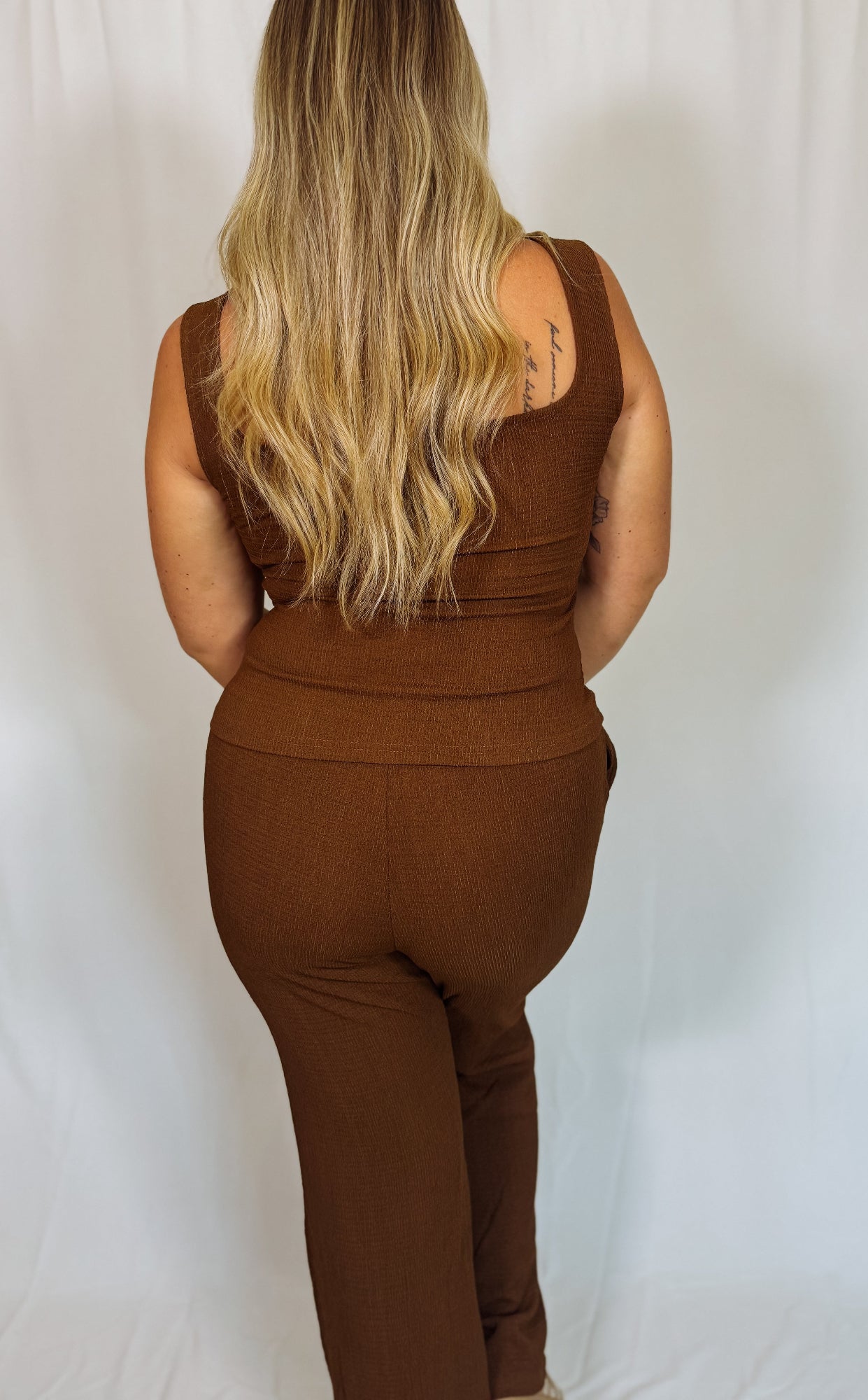 Brown tank top and pant set worn by a person on a white background