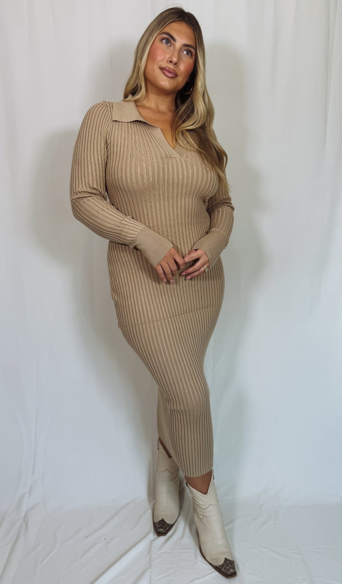 Woman wearing a beige ribbed dress and white boots against a white background