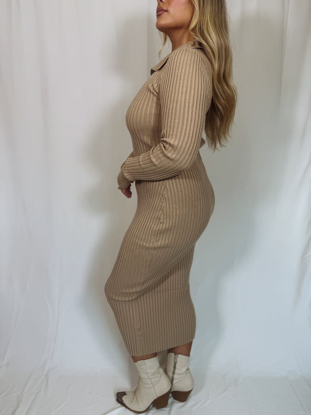 Woman wearing a beige ribbed knit dress against a white background