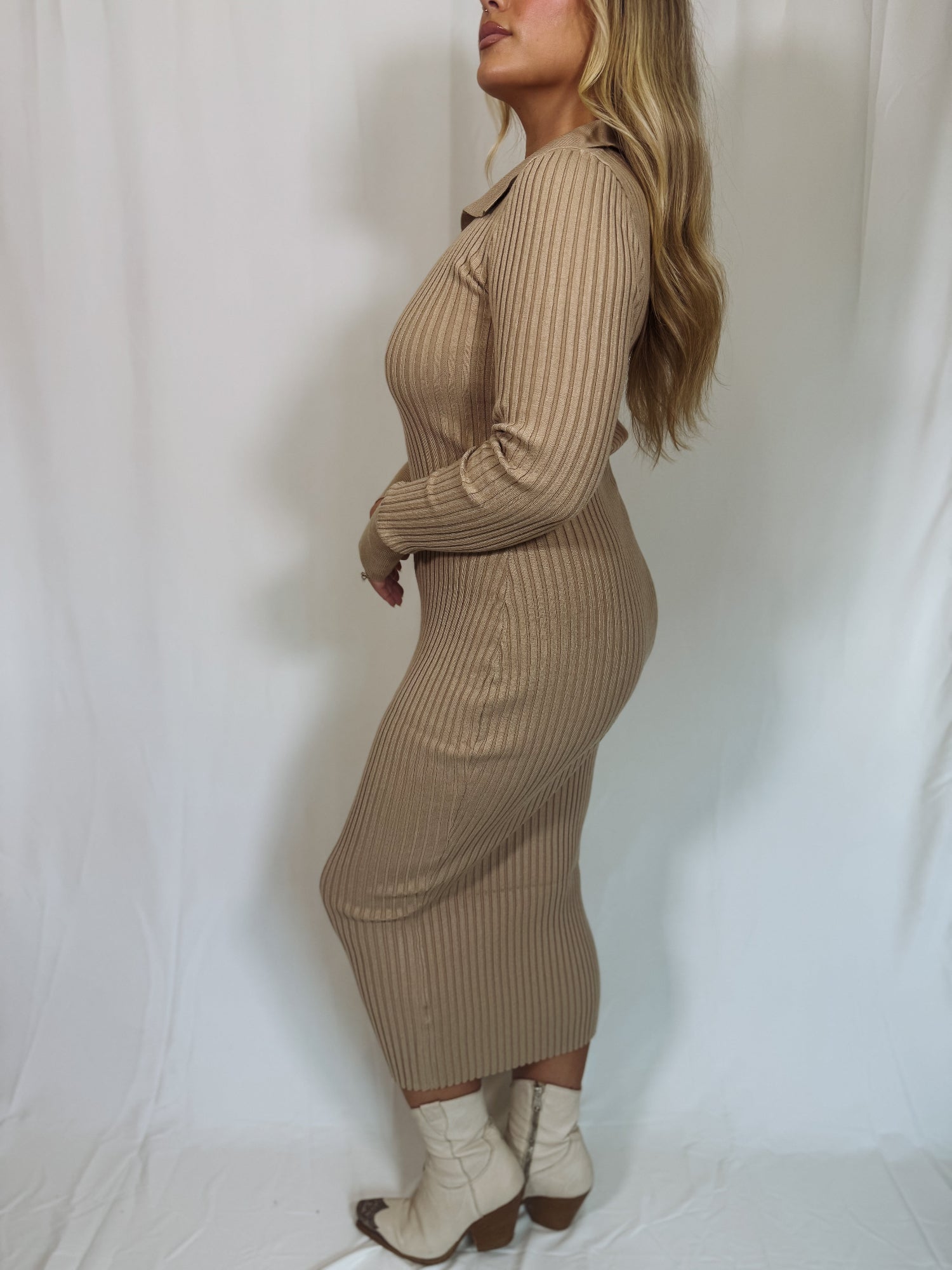 Woman wearing a beige ribbed knit dress against a white background