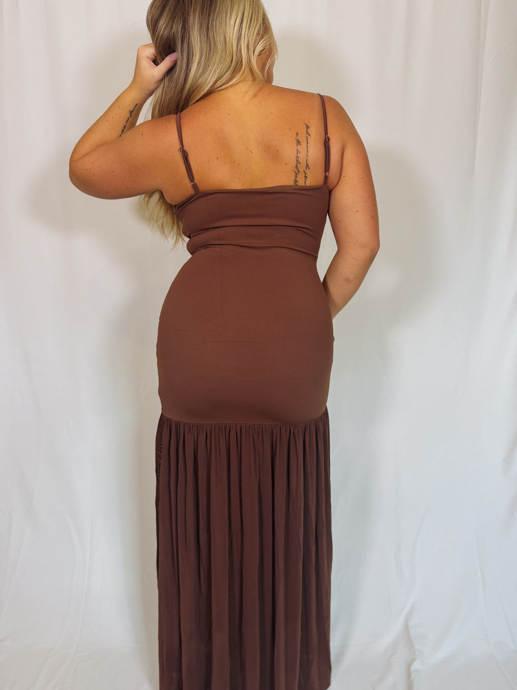 Woman wearing a brown dress against a white background