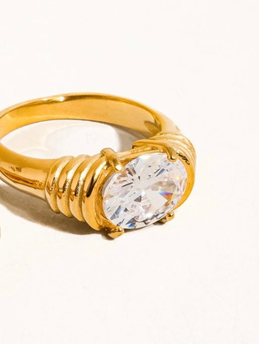 Gold ring with a large diamond on a white background