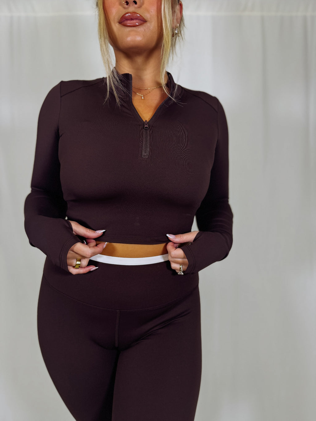 Person wearing a dark brown athletic outfit against a plain background